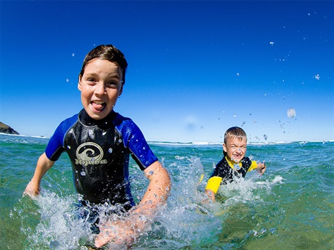 Two kids splashing at the beach