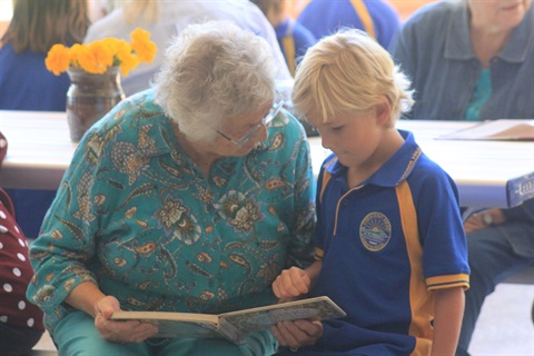 senior reading to younger person