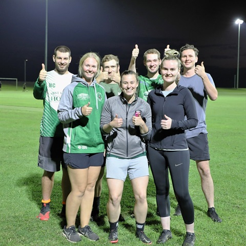 a group of people standing on a sports field