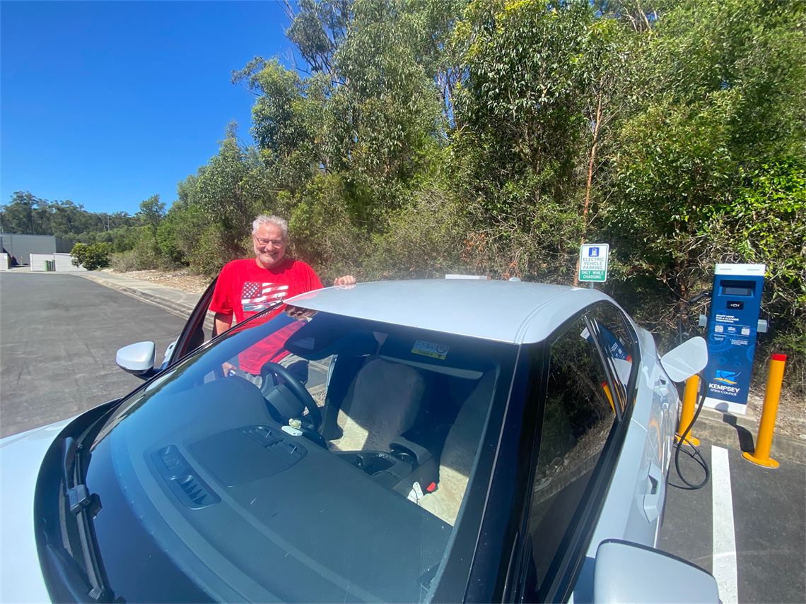 A man charging his electric vehicle